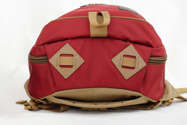 Red backpack with brown accents on a white background